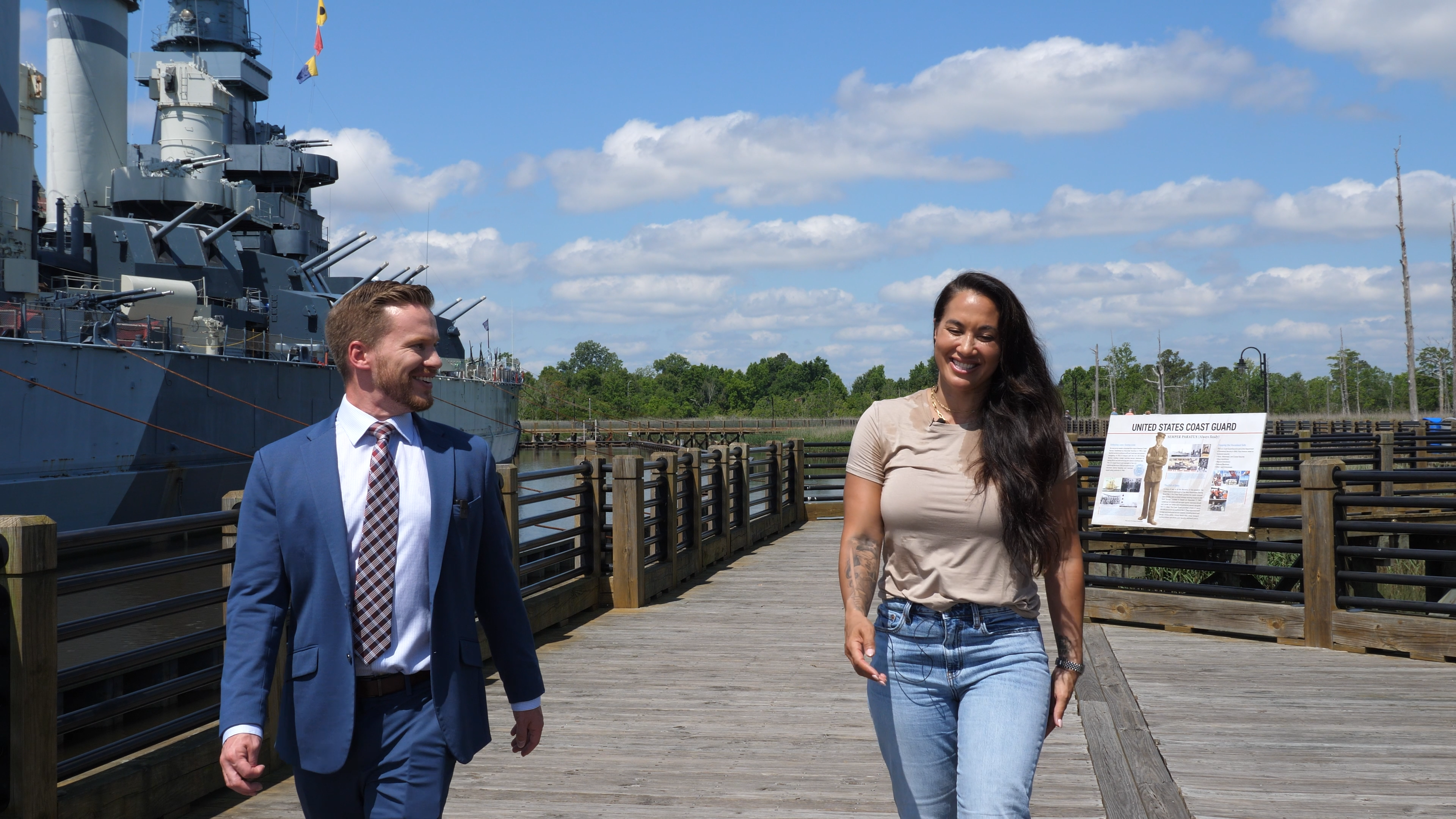 Matt Bennett walking with an interview subject beside a ship